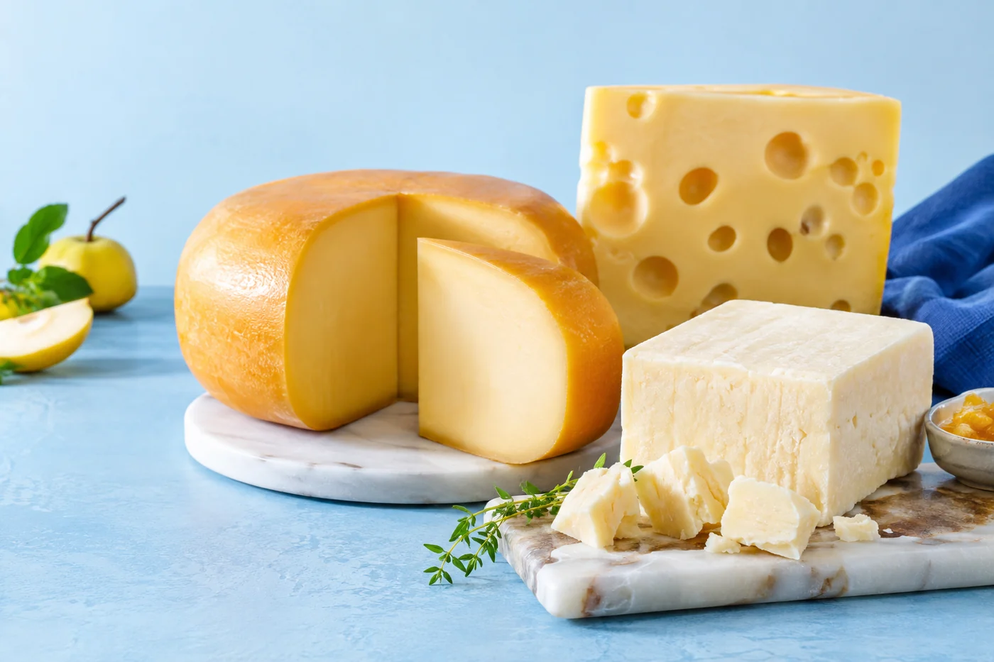 Illustrative Gouda, Cheddar and Emmental selection on a stainless steel surface